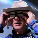 Jeff Bezos holds aviation glasses