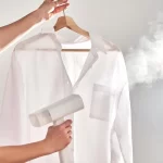 "Close-up of Hand Holding Clothes Steamer with Billowing Steam