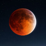 96% partial blood moon over mountains at night