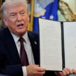 Trump holding a signed executive order